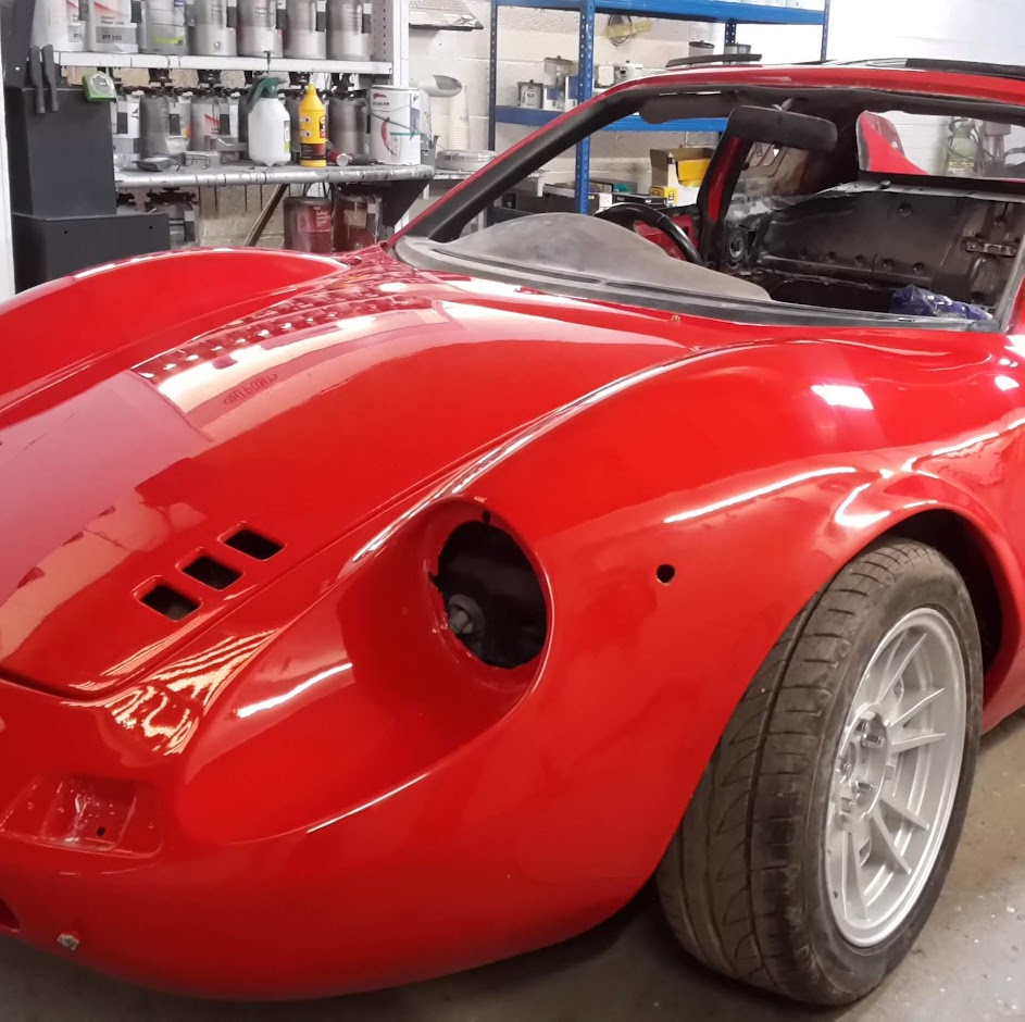 Red classic sports car freshly painted in the workshop